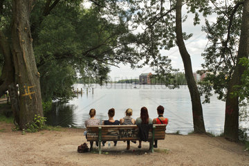Berlin  Deutschland  fuenf junge Frauen sitzen auf einer Parkbank am Paul-und-Paula-Ufer