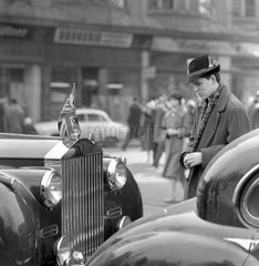 Berlin  DDR  junger Mann mit Hut schaut erstaunt auf ein Auto mit der Nationalfahne von Grossbritannien am Kuehler