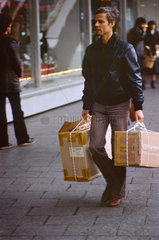 Berlin  DDR  Mann kommt vom Einkaufen mit verschnuerten Paketen