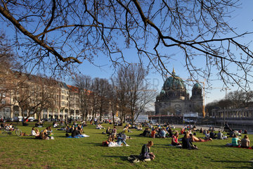 Berlin  Deutschland  junge Leute sitzen im Fruehjahr auf dem Rasen