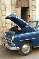 Havanna  Kuba  Mann bastelt an seinem Chevrolet