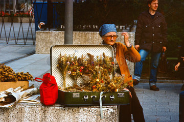 Berlin  DDR  Frau verkauft auf dem Alexanderplatz Blumenstraeusse aus einem Koffer