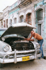 Cienfuegos  Kuba  Mann bastelt an seinem Chevrolet