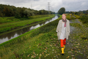 Oberhausen  Deutschland  eine junge Frau geht bei Regenwetter an der Emscher spazieren