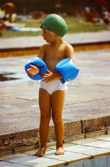 Berlin  DDR  Kind mit Badekappe und Schwimmfluegeln in einem Freibad