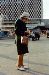 Berlin  DDR  alte Frau schaut auf dem Alexanderplatz in ihre Geldboerse