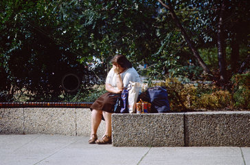 Berlin  DDR  Frau sitzt verzweifelt in einem Park