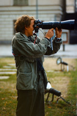 Berlin  DDR  Mann fotografiert mit einem Teleobjektiv