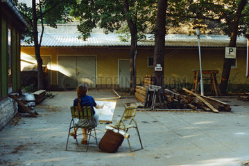 Berlin  DDR  eine Frau malt ein Bild im leeren Prater Garten