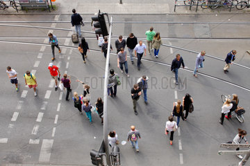 Berlin  Deutschland  Passanten ueberqueren eine Strasse an einer Fussgaengerampel