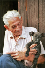 Santiago de Cuba  Kuba  aelterer Mann mit seinem Hund