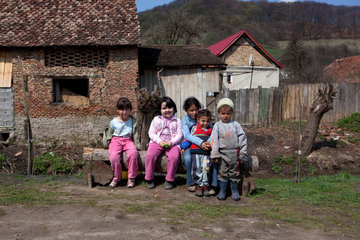 Biertan  Rumaenien  Zigeunerkinder sitzen gemeinsam auf einer Bank