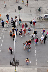 Berlin  Deutschland  Passanten ueberqueren eine Strasse an einer Fussgaengerampel