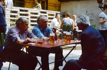 Berlin  DDR  Maenner sitzen in einem Lokal und trinken Bier