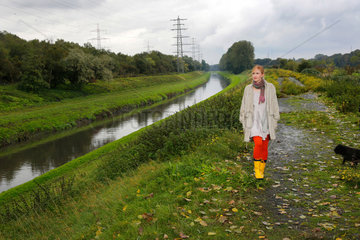Oberhausen  Deutschland  eine junge Frau geht bei Regenwetter an der Emscher spazieren