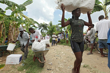 Leogane  Haiti  eine Frau transportiert Hilfsgueter auf dem Kopf