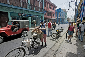 Santiago de Cuba  Kuba  Mann verkauft vom seinem Fahrrad aus Mamey-Fruechte