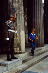Berlin  DDR  Junge laeuft an einem Soldaten der Ehrenwache der NVA vorbei