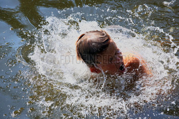 Briescht  Deutschland  Junge schuettelt seinen Kopf beim Schwimmen in einem See