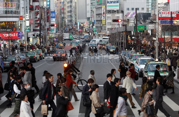 Tokio  Japan  Fussgaenger ueberqueren eine Strasse im Stadtteil Shinjuku