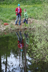 Neu Kaetwin  Deutschland  Kinder stehen beim Angeln an einem Teich