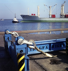 Rostock  DDR  Schlepper zieht einen Frachtkahn im Ueberseehafen Rostock