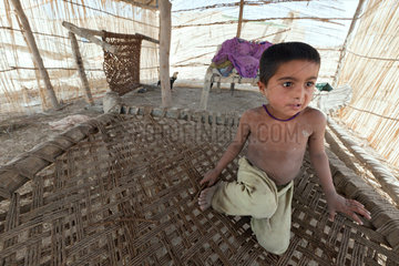 Lujja Khan Jakrani  Pakistan  kleiner Junge sitzt auf seinem Bett