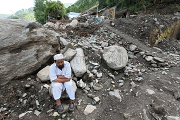 Kokarai  Pakistan  ein Mann vor den Truemmern seines Hauses nach der Hochwasser-Katastrophe