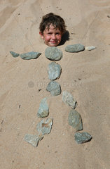 Santa Margherita di Pula  Italien  Junge ist im Sand eingebuddelt