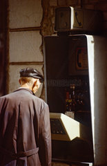 Berlin  DDR  Mann betrachtet eine kaputte Telefonzelle