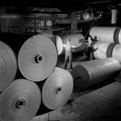 A worker arranges huge rolls of cardboard in storeroom  Bolton   1957.