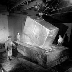 Three men raise large steel tank from the galvanising bath  1966.