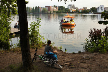 Berlin  Deutschland  Grillboot und Mann am Ufer der Rummelsburger Bucht