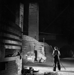 A kiln worker samples fired kilns at night  Wheatley Quarries 1955.