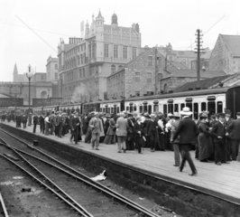 Passengers at a railway station  c 1905.