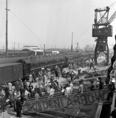 Passengers disembarking a ferry and boarding a train in the harbour  1950.