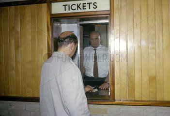 Traveller buying railway ticket  Olympia Station  London  1963.