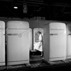 A female production line worker inspects refrigerators  1954.