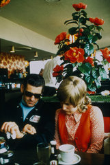 Couple sitting in a motorway service station  c 1972.