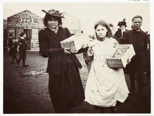 Woman and girl selling souvenirs  c 1900.