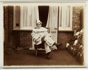 Smoking man dressed as a clown  c 1930.