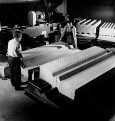 Two employees load sheets of corrugated asbestos and cement  1961.