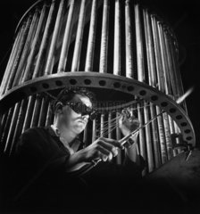 A worker solders fibular heating elements on a drum  Birlec  1956.