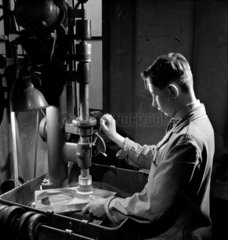A young man cuts glass for lenses  Taylor-Hobson  1953.