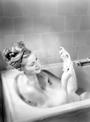 Woman having a bubble bath  1950.
