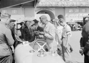 Louis Chiron and a mechanic working on a Bugatti racing car  Berlin  1933.