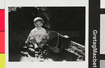 Dirty- faced young boy with a coal scuttle  c.1930.