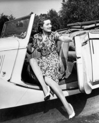 Woman getting out of a car  1940s.