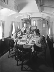 Holidaymakers having a meal in a camping coach  1936.