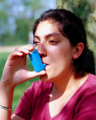 Young woman using an asthma inhaler  May 2000.
